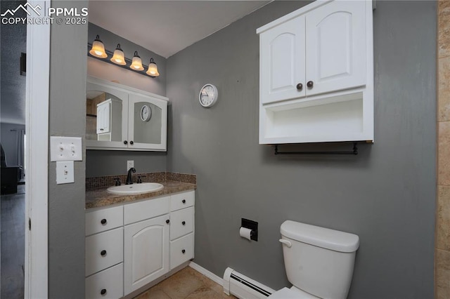 9940 N Calhan Hwy, Calhan, CO 80808 - bathroom featuring a baseboard radiator, vanity, toilet, tile patterned flooring, and baseboards