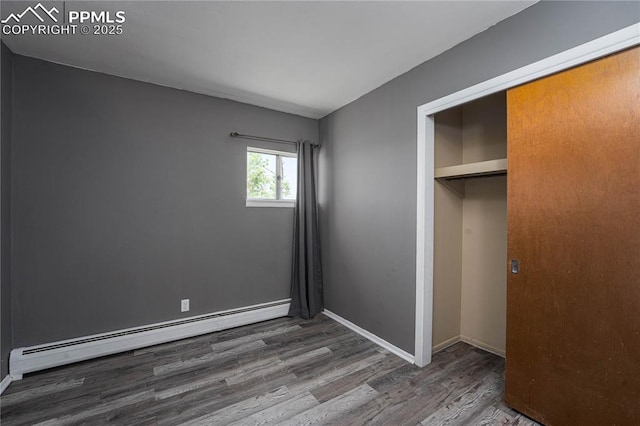 9940 N Calhan Hwy, Calhan, CO 80808 - unfurnished bedroom with baseboard heating, wood finished floors, a closet, and baseboards
