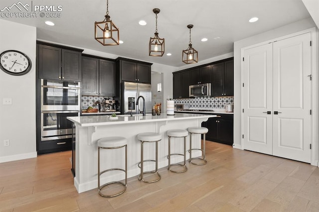 5446 Coltin Trl, Castle Rock, CO 80104 - kitchen with stainless steel appliances, recessed lighting, tasteful backsplash, a breakfast bar area, and light countertops