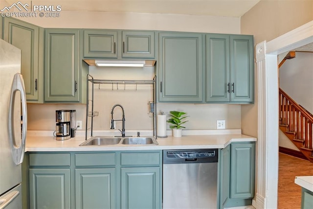 220 E 5th St, Florence, CO 81226 - kitchen featuring stainless steel appliances, a sink, light countertops, light wood-style floors, and green cabinetry