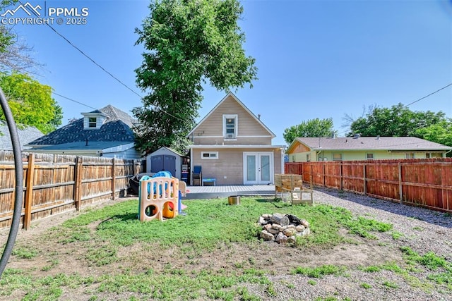 220 E 5th St, Florence, CO 81226 - back of property featuring french doors, a fenced backyard, a deck, and an outdoor fire pit