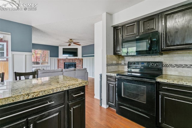 7942 French Rd, Colorado Springs, CO 80920 - kitchen with black appliances, ceiling fan, tasteful backsplash, a fireplace, and a textured ceiling