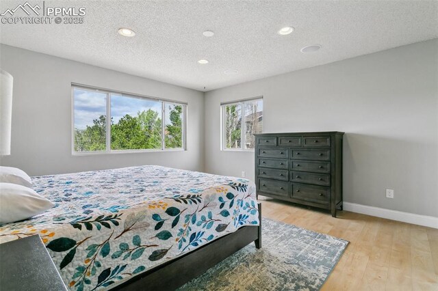 7942 French Rd, Colorado Springs, CO 80920 - bedroom with recessed lighting, baseboards, light wood-style flooring, and a textured ceiling