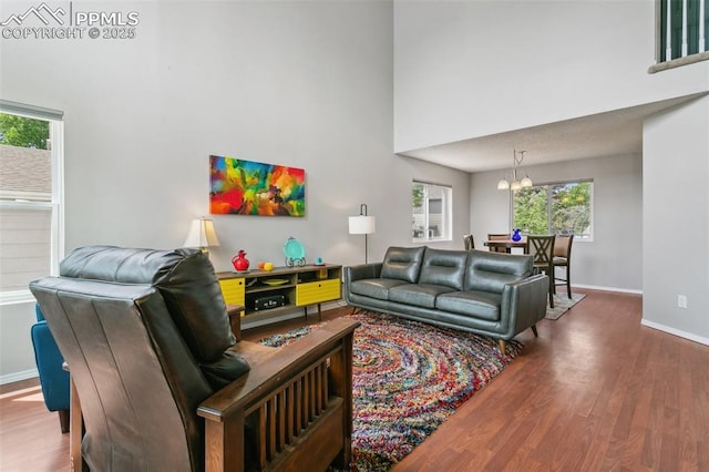 7942 French Rd, Colorado Springs, CO 80920 - living area featuring wood finished floors, a chandelier, healthy amount of natural light, and a high ceiling