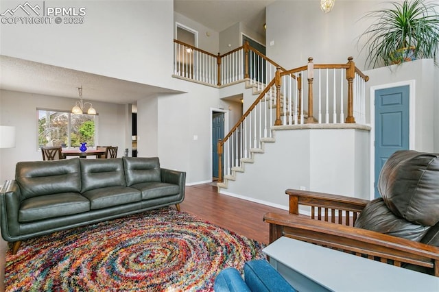 7942 French Rd, Colorado Springs, CO 80920 - living area featuring a chandelier, wood finished floors, stairway, a towering ceiling, and baseboards