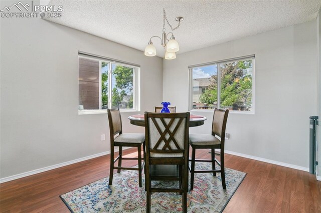 7942 French Rd, Colorado Springs, CO 80920 - dining room featuring a chandelier, a textured ceiling, wood finished floors, and baseboards