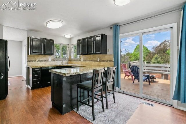 7942 French Rd, Colorado Springs, CO 80920 - kitchen with dark cabinets, backsplash, a sink, and black appliances