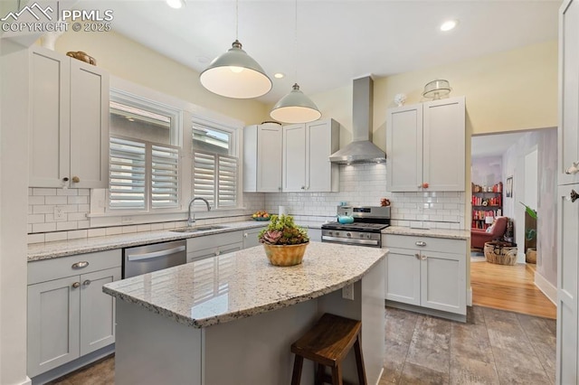 1212 W Cucharras St, Colorado Springs, CO 80904 - kitchen with wall chimney range hood, appliances with stainless steel finishes, a sink, a center island, and decorative backsplash