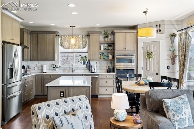 6950 Blue Mesa Ln, Littleton, CO 80125 - kitchen with appliances with stainless steel finishes, dark wood-style floors, light countertops, a kitchen island, and a sink