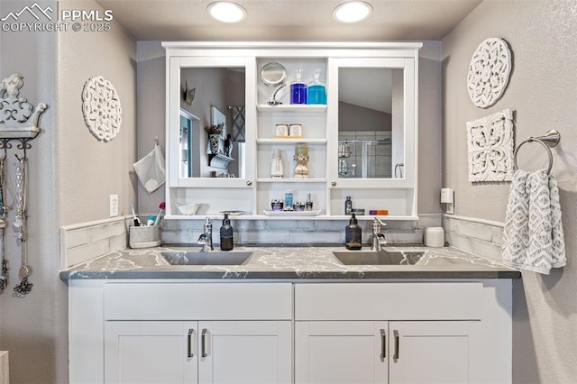 6950 Blue Mesa Ln, Littleton, CO 80125 - kitchen with a sink, white cabinets, dark stone counters, and a textured wall