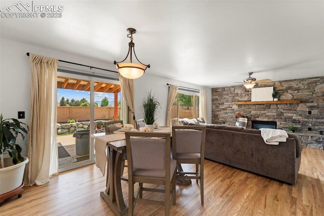 5481 Pioneer Mesa Dr, Colorado Springs, CO 80923 - dining space featuring ceiling fan, light wood-type flooring, and a stone fireplace