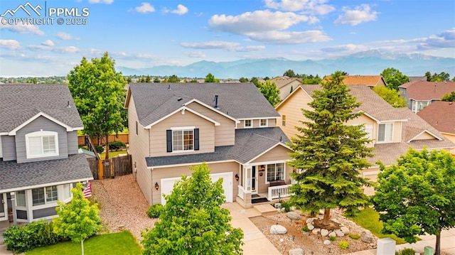 5481 Pioneer Mesa Dr, Colorado Springs, CO 80923 - traditional home featuring a garage, a shingled roof, a porch, a residential view, and driveway