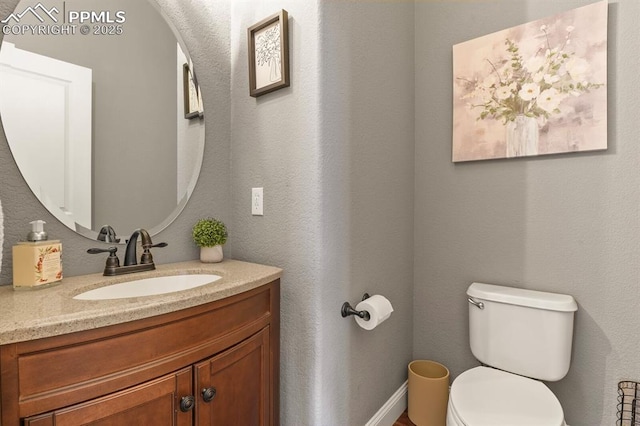 2512 Willow Glen Dr, Colorado Springs, CO 80920 - half bathroom featuring toilet, vanity, and baseboards
