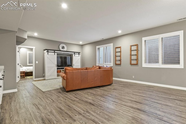 2512 Willow Glen Dr, Colorado Springs, CO 80920 - living area featuring wood finished floors, baseboards, recessed lighting, and a barn door