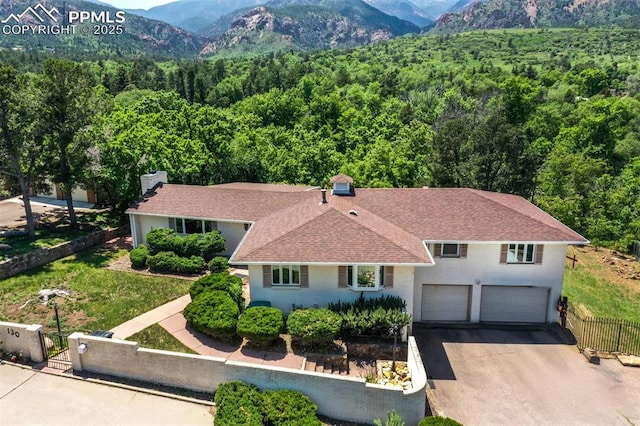 130 Cresta Rd, Colorado Springs, CO 80906 - view of front of house featuring a view of trees, driveway, an attached garage, and a mountain view