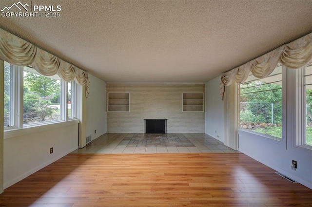130 Cresta Rd, Colorado Springs, CO 80906 - unfurnished living room featuring a textured ceiling, wood finished floors, built in features, and baseboards