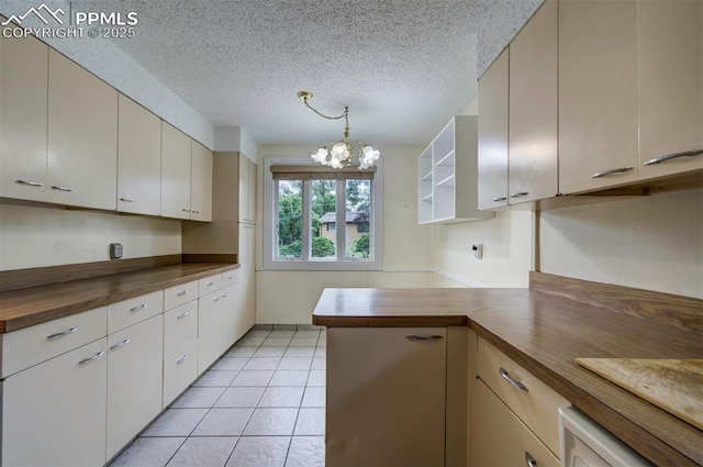 130 Cresta Rd, Colorado Springs, CO 80906 - kitchen with butcher block countertops, a chandelier, a textured ceiling, light tile patterned floors, and a peninsula
