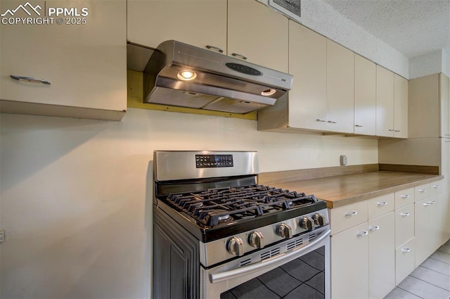 130 Cresta Rd, Colorado Springs, CO 80906 - kitchen with gas range, ventilation hood, light countertops, a textured ceiling, and light tile patterned floors
