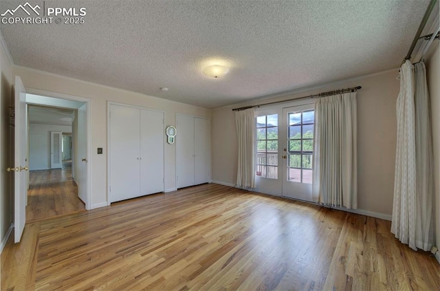 130 Cresta Rd, Colorado Springs, CO 80906 - unfurnished bedroom featuring a textured ceiling, multiple closets, french doors, light wood-type flooring, and baseboards
