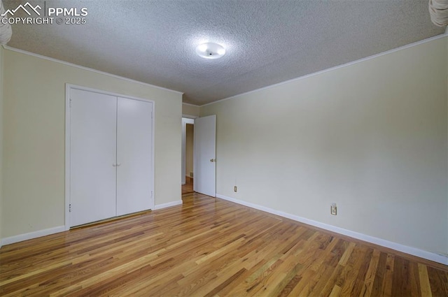 130 Cresta Rd, Colorado Springs, CO 80906 - unfurnished bedroom featuring a textured ceiling, wood finished floors, ornamental molding, baseboards, and a closet
