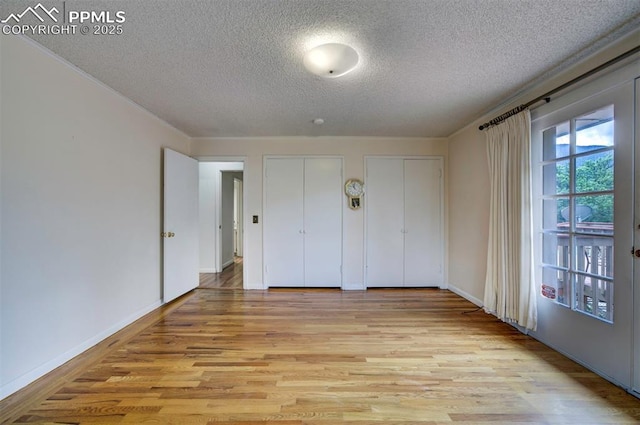 130 Cresta Rd, Colorado Springs, CO 80906 - unfurnished bedroom with a textured ceiling, multiple closets, light wood-type flooring, and baseboards