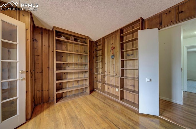130 Cresta Rd, Colorado Springs, CO 80906 - unfurnished room with light wood-style flooring, wooden walls, and a textured ceiling