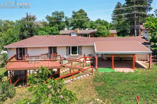 130 Cresta Rd, Colorado Springs, CO 80906 - rear view of property with roof with shingles, a wooden deck, stucco siding, and a lawn