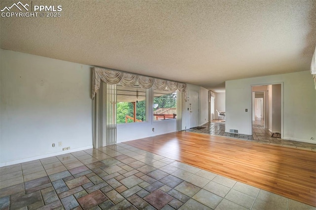 130 Cresta Rd, Colorado Springs, CO 80906 - unfurnished living room featuring a textured ceiling, wood finished floors, and baseboards