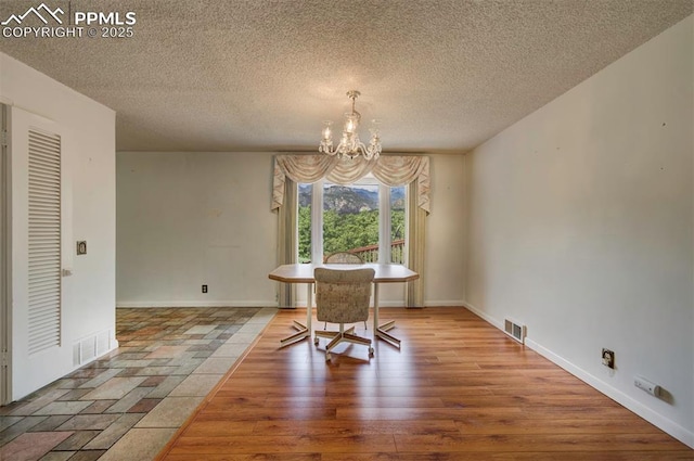 130 Cresta Rd, Colorado Springs, CO 80906 - dining room with a chandelier, a textured ceiling, baseboards, and wood finished floors