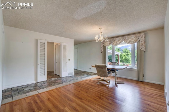 130 Cresta Rd, Colorado Springs, CO 80906 - dining area with a chandelier, wood finished floors, baseboards, and a textured ceiling