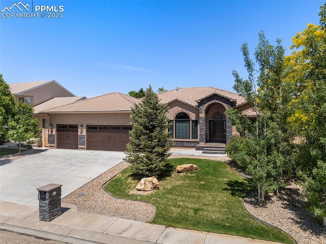 24 Redondo Ln, Pueblo, CO 81005 - view of front facade with a garage, a tiled roof, stucco siding, concrete driveway, and a front yard