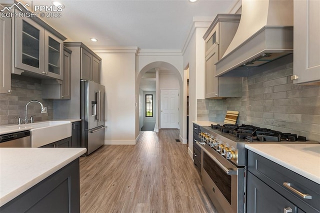 24 Redondo Ln, Pueblo, CO 81005 - kitchen with high quality appliances, premium range hood, arched walkways, baseboards, and light countertops