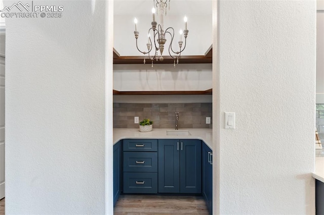 24 Redondo Ln, Pueblo, CO 81005 - bar area with decorative backsplash, a chandelier, wood finished floors, a sink, and a textured wall