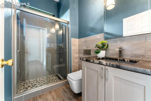 24 Redondo Ln, Pueblo, CO 81005 - full bathroom with vanity, toilet, a stall shower, wood finished floors, and decorative backsplash