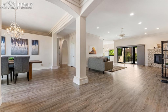 24 Redondo Ln, Pueblo, CO 81005 - living room with ornamental molding, arched walkways, a chandelier, baseboards, and wood finished floors