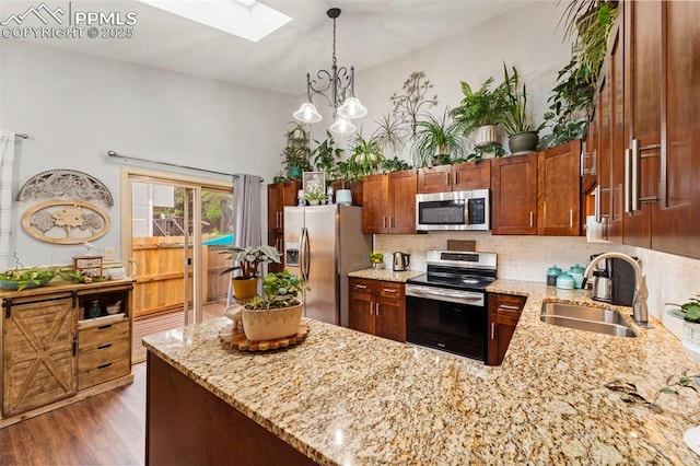 6150 Fall River Dr, Colorado Springs, CO 80918 - kitchen featuring stainless steel appliances, a sink, a skylight, light stone countertops, and tasteful backsplash