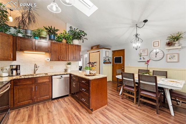 6150 Fall River Dr, Colorado Springs, CO 80918 - kitchen with appliances with stainless steel finishes, a sink, a skylight, a peninsula, and light wood finished floors