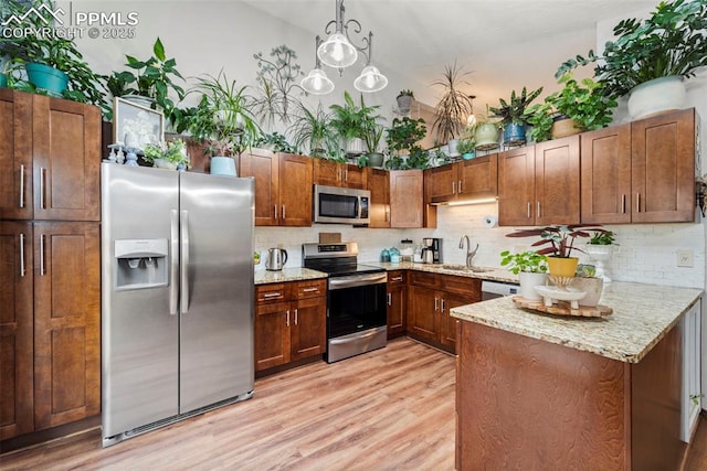 6150 Fall River Dr, Colorado Springs, CO 80918 - kitchen with stainless steel appliances, light wood-style flooring, tasteful backsplash, and light stone counters