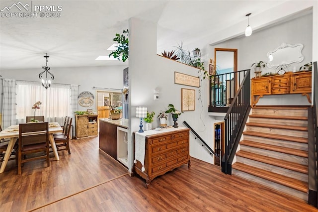 6150 Fall River Dr, Colorado Springs, CO 80918 - kitchen featuring lofted ceiling, wood finished floors, a chandelier, and decorative light fixtures