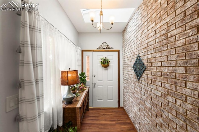 6150 Fall River Dr, Colorado Springs, CO 80918 - entryway with brick wall, dark wood finished floors, a chandelier, an accent wall, and a skylight