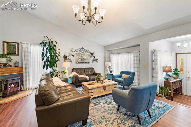 6150 Fall River Dr, Colorado Springs, CO 80918 - living area featuring a chandelier, lofted ceiling, wood finished floors, healthy amount of natural light, and a fireplace
