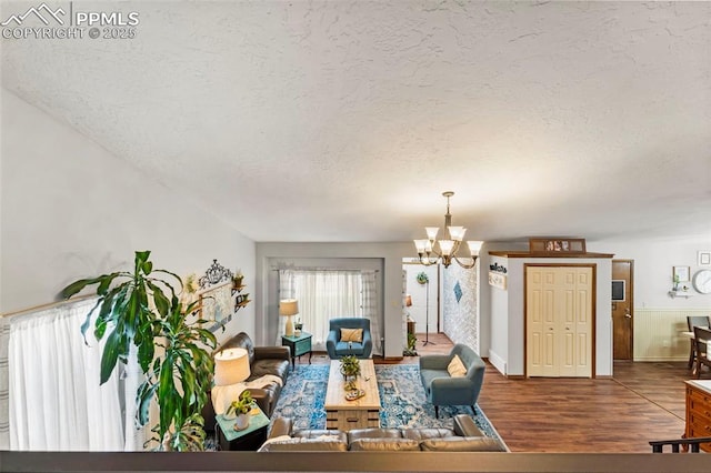 6150 Fall River Dr, Colorado Springs, CO 80918 - living area with a textured ceiling, a chandelier, wood finished floors, and baseboards