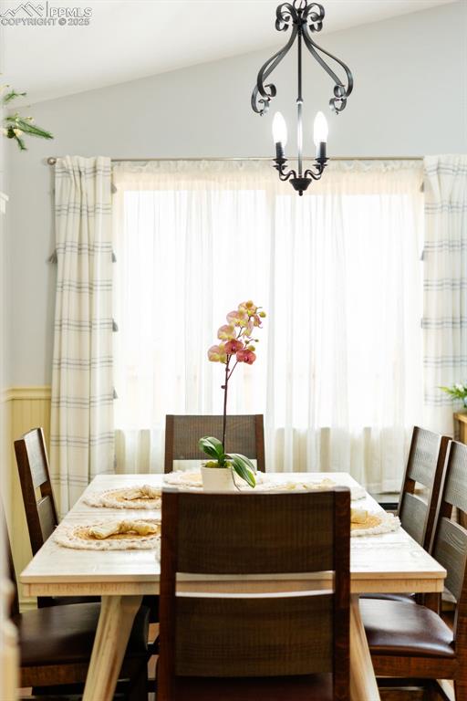 6150 Fall River Dr, Colorado Springs, CO 80918 - dining area with healthy amount of natural light, a chandelier, and a wainscoted wall