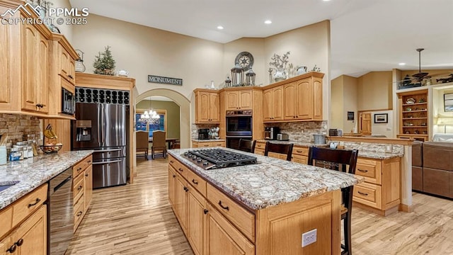 17910 Queensmere Dr, Monument, CO 80132 - kitchen featuring appliances with stainless steel finishes, light wood-type flooring, a kitchen island, tasteful backsplash, and recessed lighting