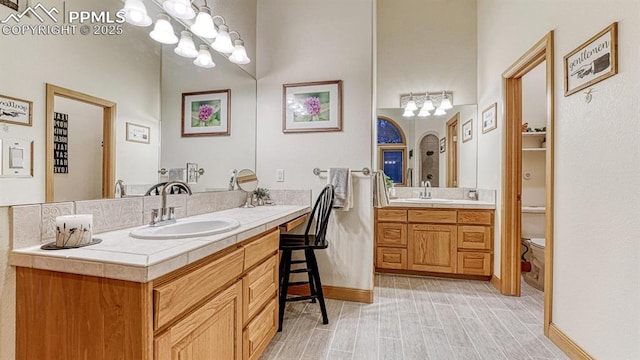 17910 Queensmere Dr, Monument, CO 80132 - full bathroom with vanity, toilet, a chandelier, and wood finished floors