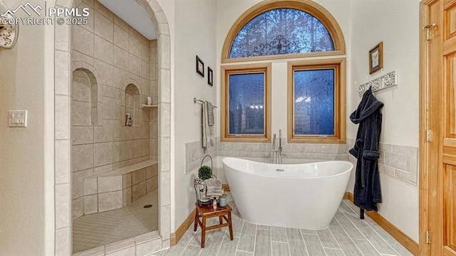 17910 Queensmere Dr, Monument, CO 80132 - bathroom with a freestanding bath, walk in shower, wainscoting, and tile walls