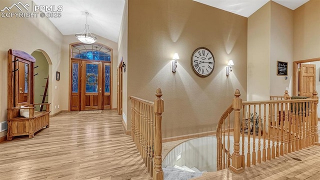 17910 Queensmere Dr, Monument, CO 80132 - foyer entrance featuring wood finished floors, arched walkways, baseboards, and high vaulted ceiling