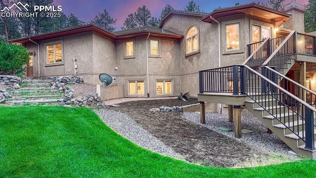 17910 Queensmere Dr, Monument, CO 80132 - rear view of house featuring stairs, a wooden deck, a lawn, and stucco siding