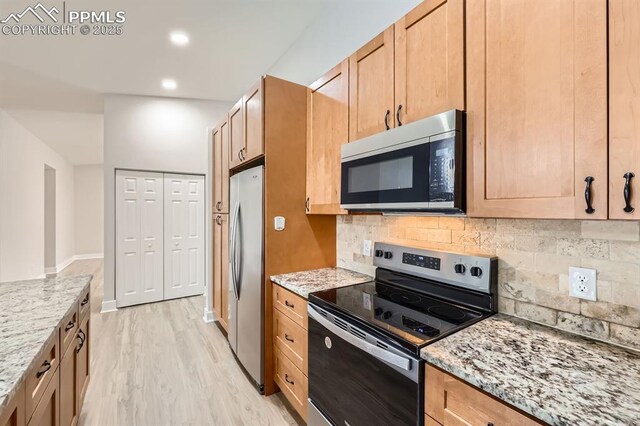 610 E San Gabriel Pl, Colorado Springs, CO 80906 - kitchen featuring appliances with stainless steel finishes, decorative backsplash, light wood-style floors, light stone countertops, and recessed lighting