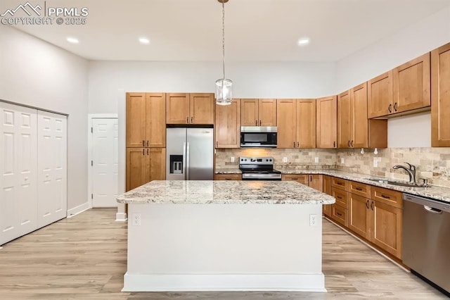 610 E San Gabriel Pl, Colorado Springs, CO 80906 - kitchen with stainless steel appliances, decorative backsplash, a center island, light wood-style flooring, and recessed lighting